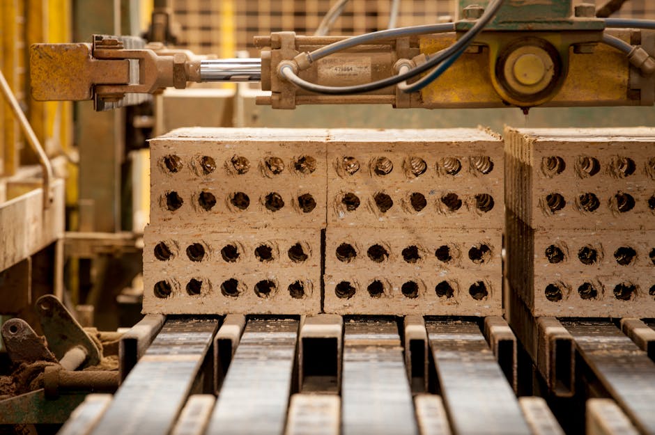 Close-up of machinery producing bricks in a factory. Precision and efficiency in industrial manufacturing.