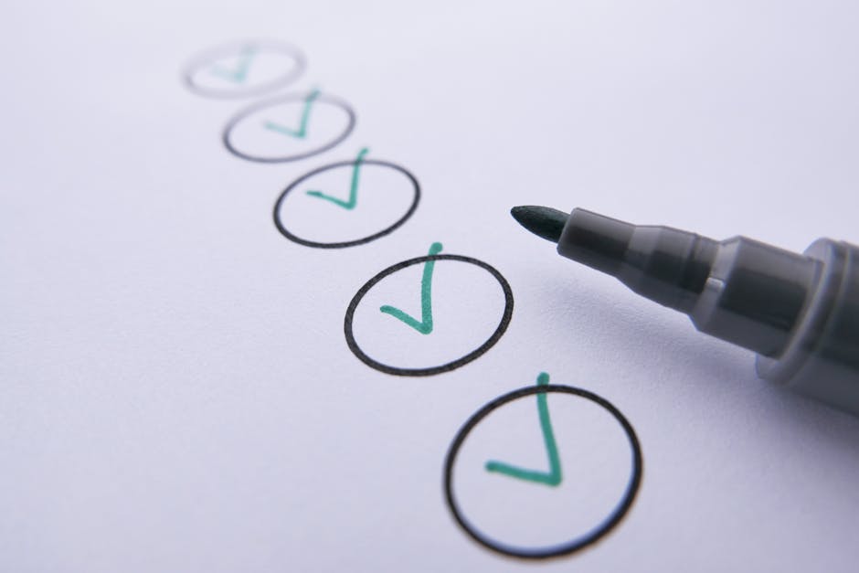 Close-up of a checklist with green checkmarks on white paper using a marker.