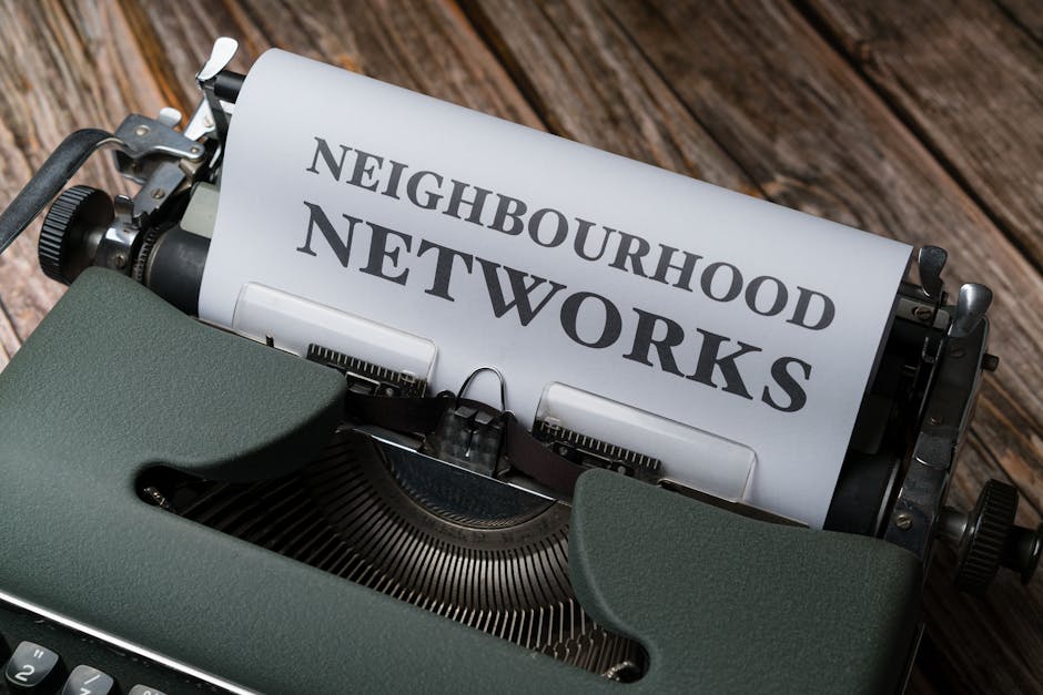 A vintage typewriter displaying the text 'Neighbourhood Networks' on a wooden desk.