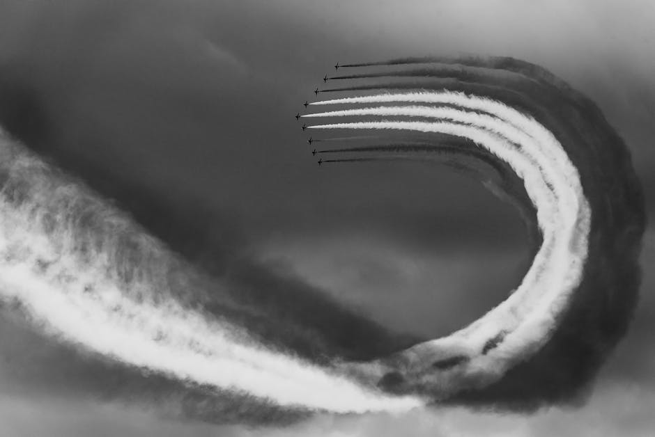 Black and white photo capturing jets in an aerial formation with smoke trails.