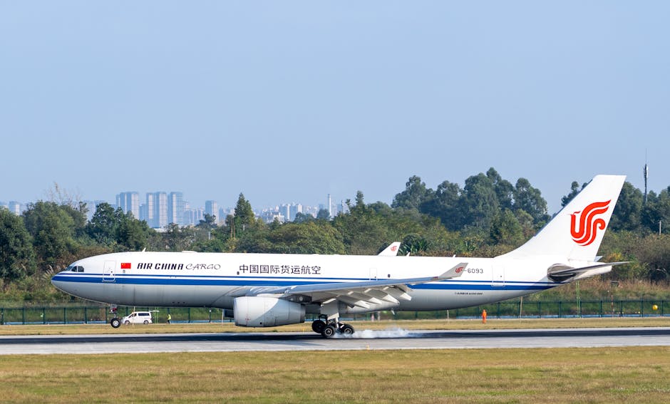 Air China Cargo plane landing on a runway with cityscape and trees in the background.