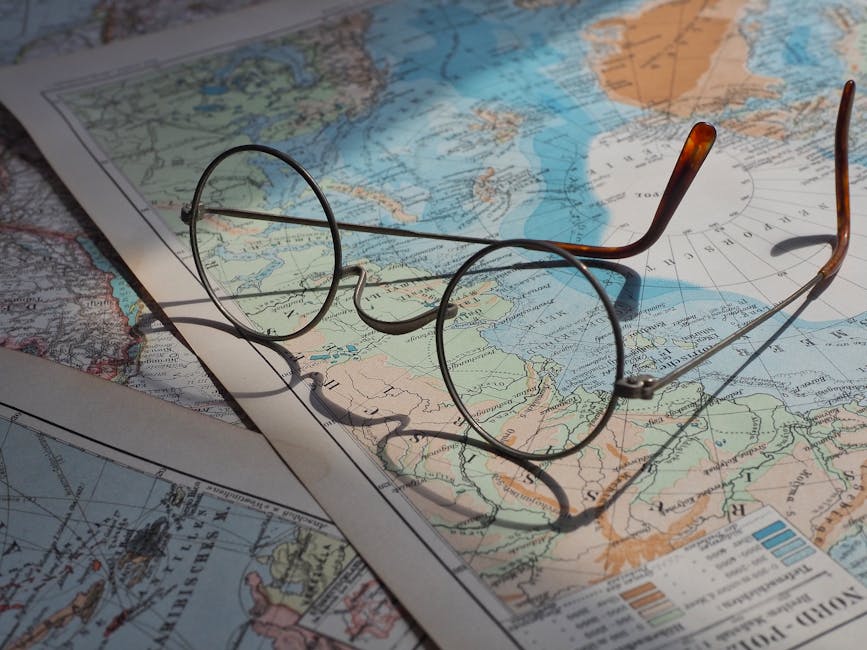 Round vintage eyeglasses resting on a vibrant historical world map, capturing a sense of exploration.