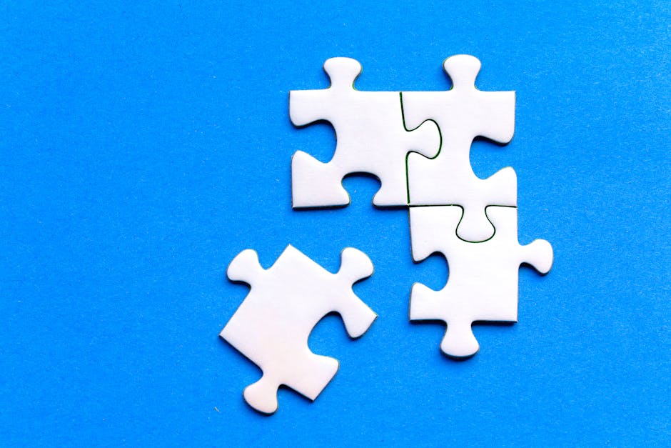White jigsaw puzzle pieces against a solid blue background, showcasing a flat lay arrangement.