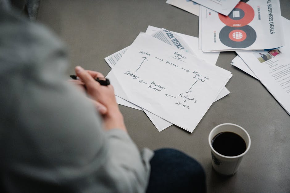 Cozy workspace with papers, plans, and a cup of coffee, perfect for brainstorming and planning sessions.