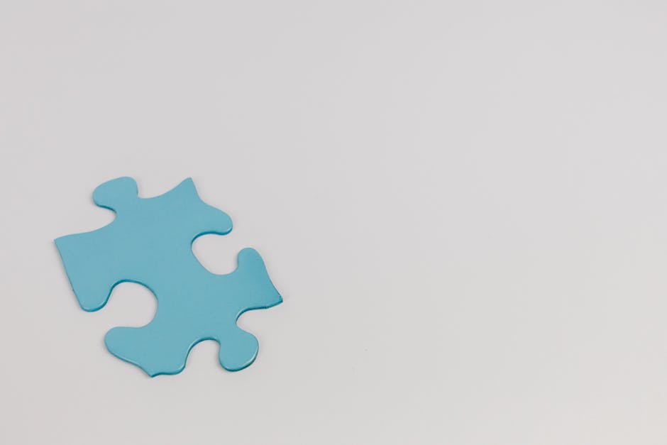 Minimalist photo of a single blue puzzle piece on a white background symbolizing autism awareness.
