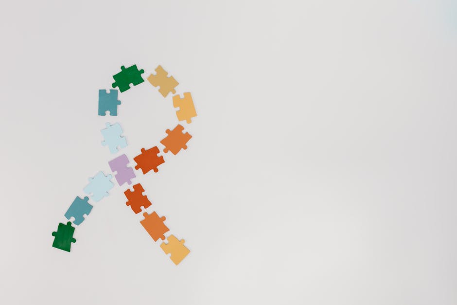 A ribbon shape made from colorful puzzle pieces on a white background symbolizing awareness.