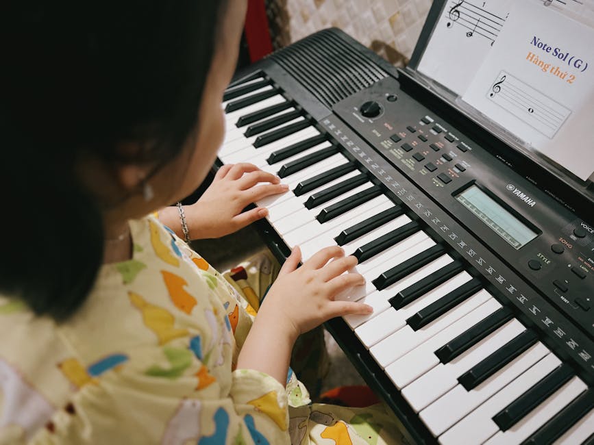 A young child practicing music on a digital keyboard indoors.